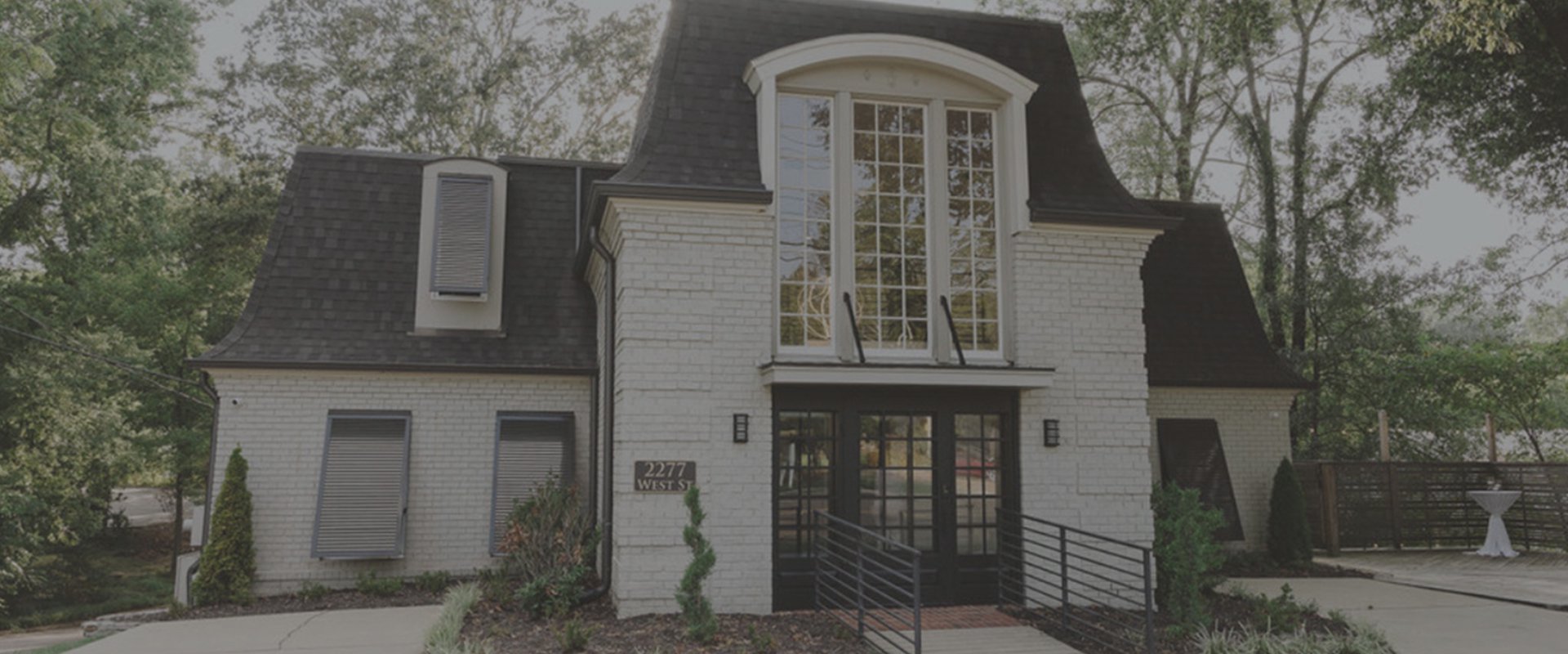 Outside of Pike & West venue - a white brick carriage house style building